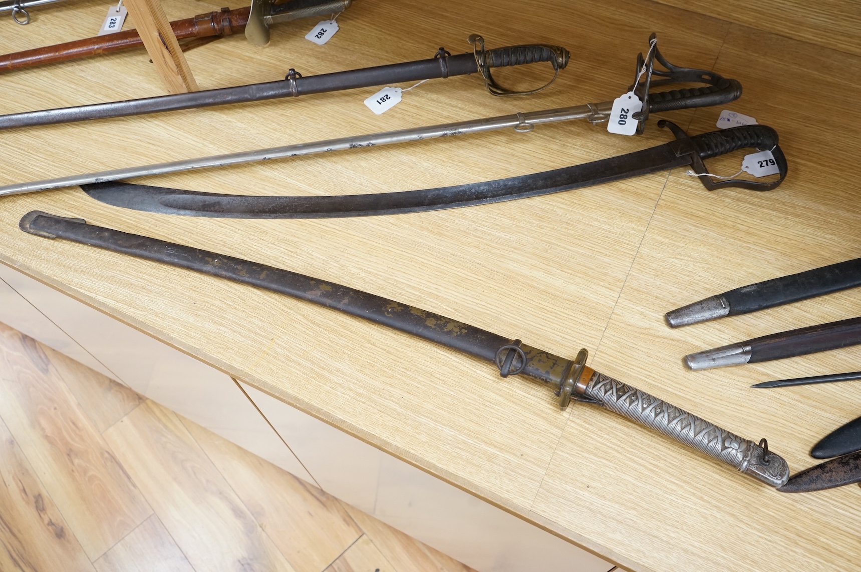 A Japanese World War II NCO‘s sword katana, regulation blade with fuller, stamped 33271, regulation aluminium hilt, brass guard, the spring catch still retains, in an iron scabbard
